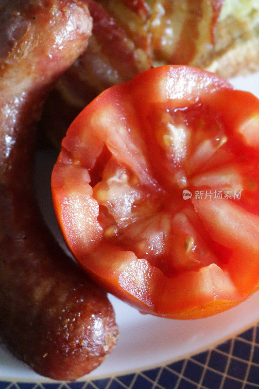 近距离拍摄的花切西红柿和香肠作为油炸早餐的一部分/油炸的气泡和吱吱声和法国吐司/鸡蛋面包，俯瞰